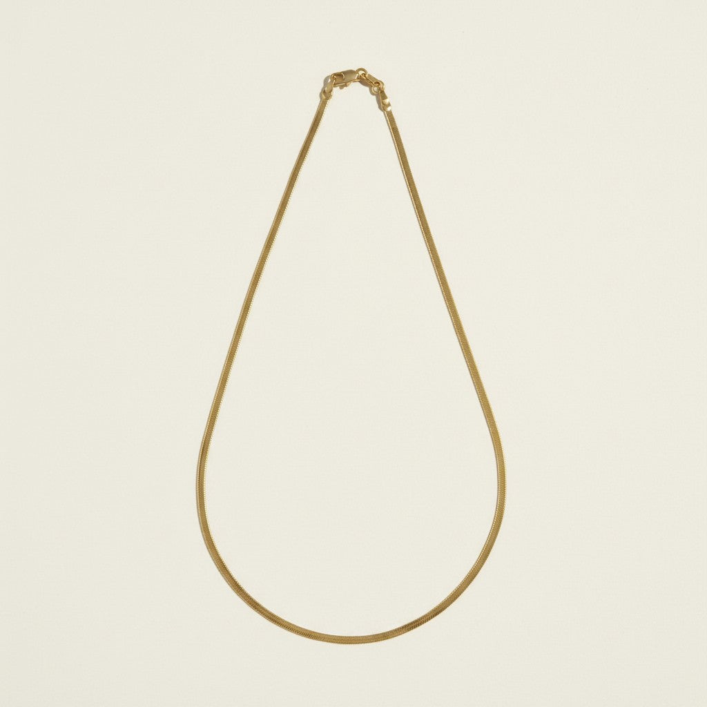 2mm herringbone chain flat lay, thin gold herringbone necklace, 18k gold overlay chain detail, dainty herringbone necklace, gold chain clasp detail, slim flat link necklace, layering herringbone chain, minimalist gold necklace