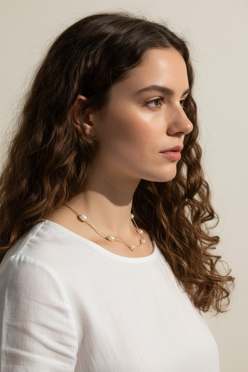 gold pearl station necklace, pearl chain necklace, freshwater pearl necklace, dainty pearl necklace on model, gold and pearl jewelry, scattered pearl necklace, layering pearl necklace, delicate pearl chain