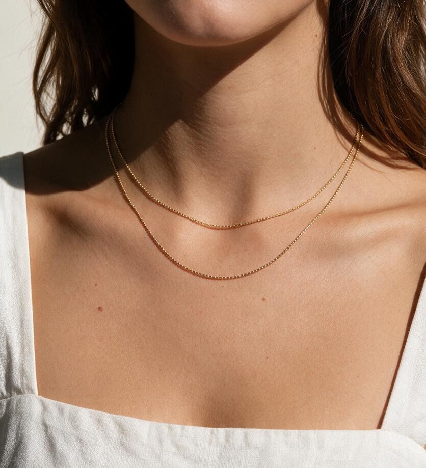 layered gold ball chain necklace, dainty bead chain necklace on model, faceted gold chain, thin gold layering necklaces, two layer gold necklace, minimalist gold necklace, delicate gold chain, collarbone necklace, everyday gold necklace, sparkly gold bead chain, women’s layering necklace, summer gold necklace