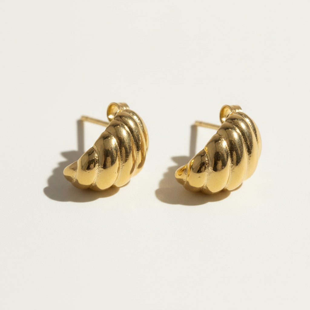 ribbed gold hoop earrings flat lay, fluted gold dome earrings detail, croissant hoop earrings, sculptural ribbed earrings, high polish gold hoops, textured gold stud earrings, retro gold earrings, gold dome earring construction