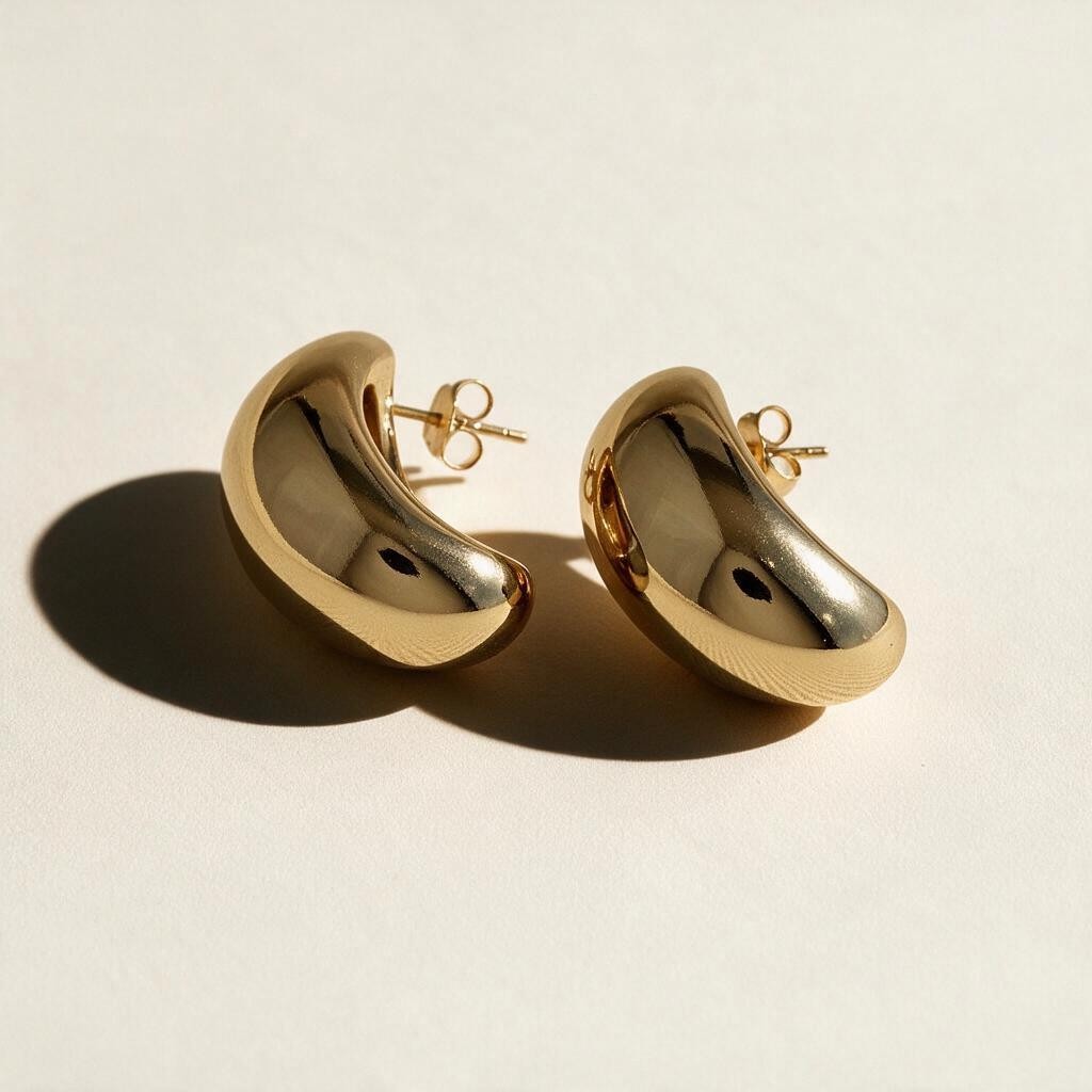 chunky dome stud earrings flat lay, gold bean earrings detail, bold gold stud earrings, 18k gold overlay earrings, statement earrings, oval dome earrings, thick gold earrings, sculptural gold earrings