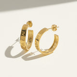 roman numeral hoop earrings, engraved gold hoop earrings, gold hoop earrings flat lay, numeral motif earrings, small gold hoops, post back hoop earrings, everyday gold jewelry, minimalist statement earrings