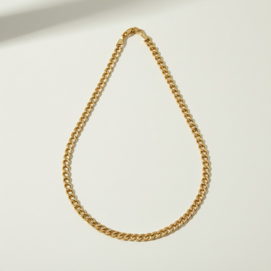 curb chain necklace flat lay, gold curb link necklace detail, classic chain necklace, layered chain necklace, clasp detail necklace, polished chain necklace, gold link necklace, layering necklace set
