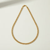curb chain necklace flat lay, gold curb link necklace detail, classic chain necklace, layered chain necklace, clasp detail necklace, polished chain necklace, gold link necklace, layering necklace set