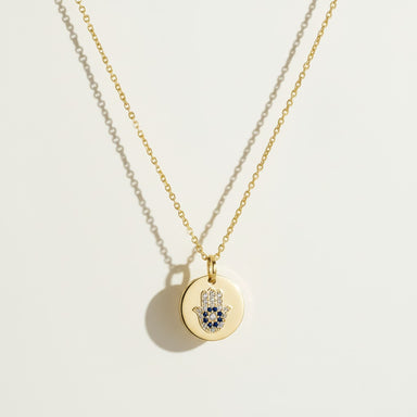 hamsa pendant necklace, gold coin necklace, hamsa coin pendant, blue crystal hamsa necklace, dainty gold pendant, protective charm necklace, round disc pendant necklace, hamsa necklace detail