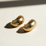 chunky dome stud earrings flat lay, gold bean earrings detail, bold gold stud earrings, 18k gold overlay earrings, statement earrings, oval dome earrings, thick gold earrings, sculptural gold earrings