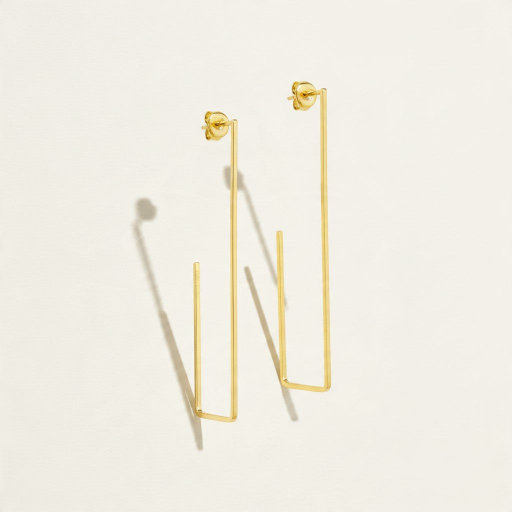 gold rectangle earrings, long geometric earrings, minimalist gold wire earrings, open rectangle hoop earrings, modern gold drop earrings, lightweight statement earrings, architectural earrings, thin gold wire earrings, elongated hoop earrings, contemporary gold jewelry, linear gold earrings, women’s geometric earrings