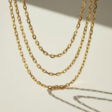  chunky gold chain necklace, oval link chain necklace, layered gold chains on model, gold cable chain necklace, statement chain necklace, graduated length chain layering, bold link necklace