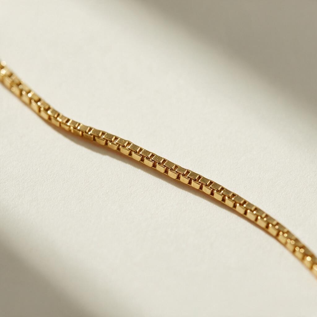 box chain bracelet flat lay, gold box link bracelet, delicate gold bracelet clasp, minimalist gold bracelet, 18k gold box chain, thin gold bracelet detail, dainty gold bracelet, gold bracelet clasp detail