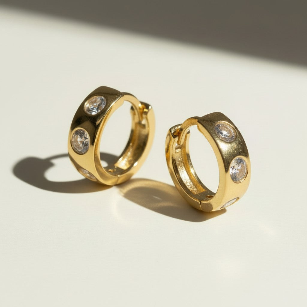 bezel set huggie hoops, crystal huggie earrings, chunky gold hoop earrings, cubic zirconia hoop earrings, 18K gold overlay huggies, statement huggie hoops, bezel stone earrings, gold hoop earrings flat lay