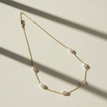 gold pearl station necklace, freshwater pearl chain necklace, pearls by the yard necklace, gold necklace with pearls, dainty pearl necklace, pearl clasp necklace, gold chain pearl jewelry, delicate pearl necklace flat lay