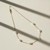 gold pearl station necklace, freshwater pearl chain necklace, pearls by the yard necklace, gold necklace with pearls, dainty pearl necklace, pearl clasp necklace, gold chain pearl jewelry, delicate pearl necklace flat lay
