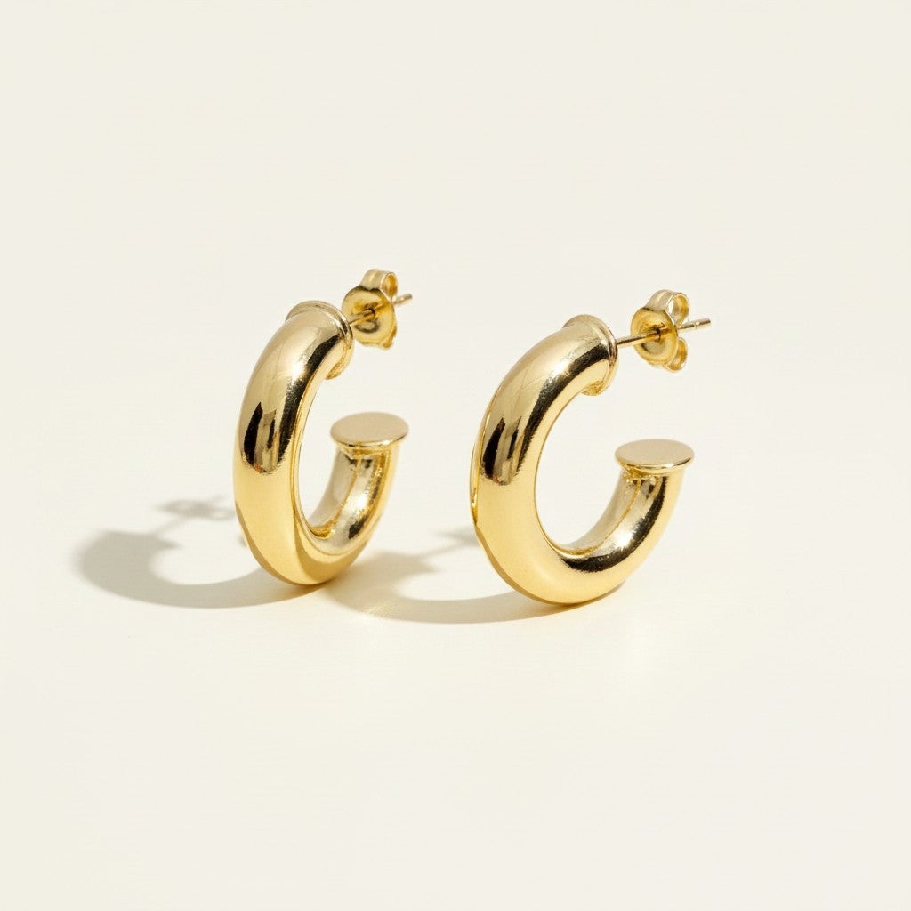 chunky round hoop earrings flat lay, gold tube hoop earrings detail, bold gold hoops, small chunky hoops, polished round hoops, statement gold hoops, everyday hoop earrings, thick gold hoop earrings