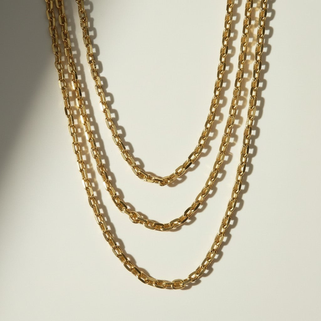  chunky gold chain necklace, oval link chain necklace, layered gold chains on model, gold cable chain necklace, statement chain necklace, graduated length chain layering, bold link necklace