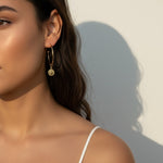 gold coin charm earrings, coin hoop earrings, gold hoop earrings with charm, vintage coin jewelry, dangle hoop earrings, everyday gold earrings, medallion earrings, on-model earring photography