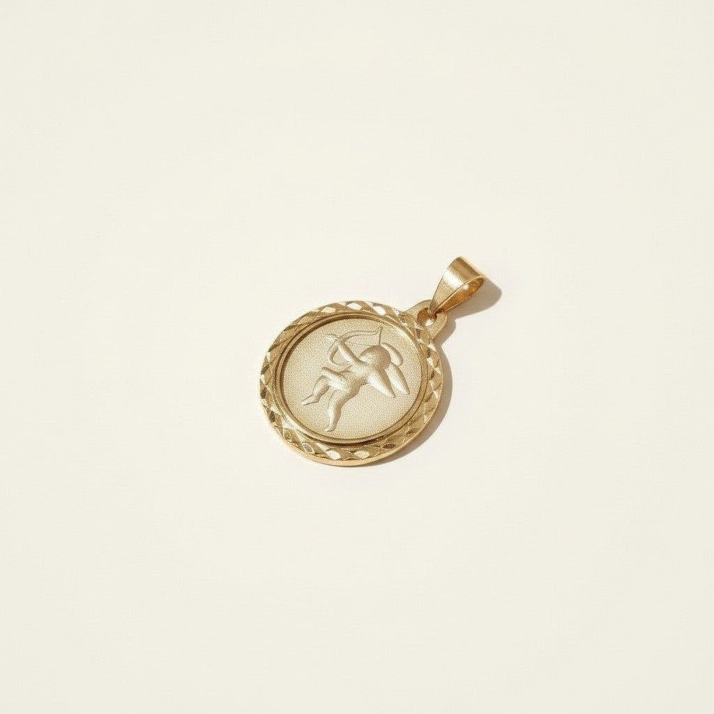 This gold pendant charm features a round medallion engraved with a cherub archer drawing a bow and arrow rendered in fine relief detail against a softly textured background. A decorative diamond-cut rope border frames the coin's edge, adding dimensional sparkle and an antique, collectible-coin character. The pendant hangs from a sturdy bail, ready to be added to a chain of your choice
