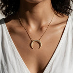 crescent moon necklace, pavé horn pendant, gold crescent necklace, celestial pendant necklace, moon horn necklace on model, dainty crescent jewelry, crystal crescent necklace