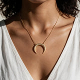 crescent moon necklace, pavé horn pendant, gold crescent necklace, celestial pendant necklace, moon horn necklace on model, dainty crescent jewelry, crystal crescent necklace