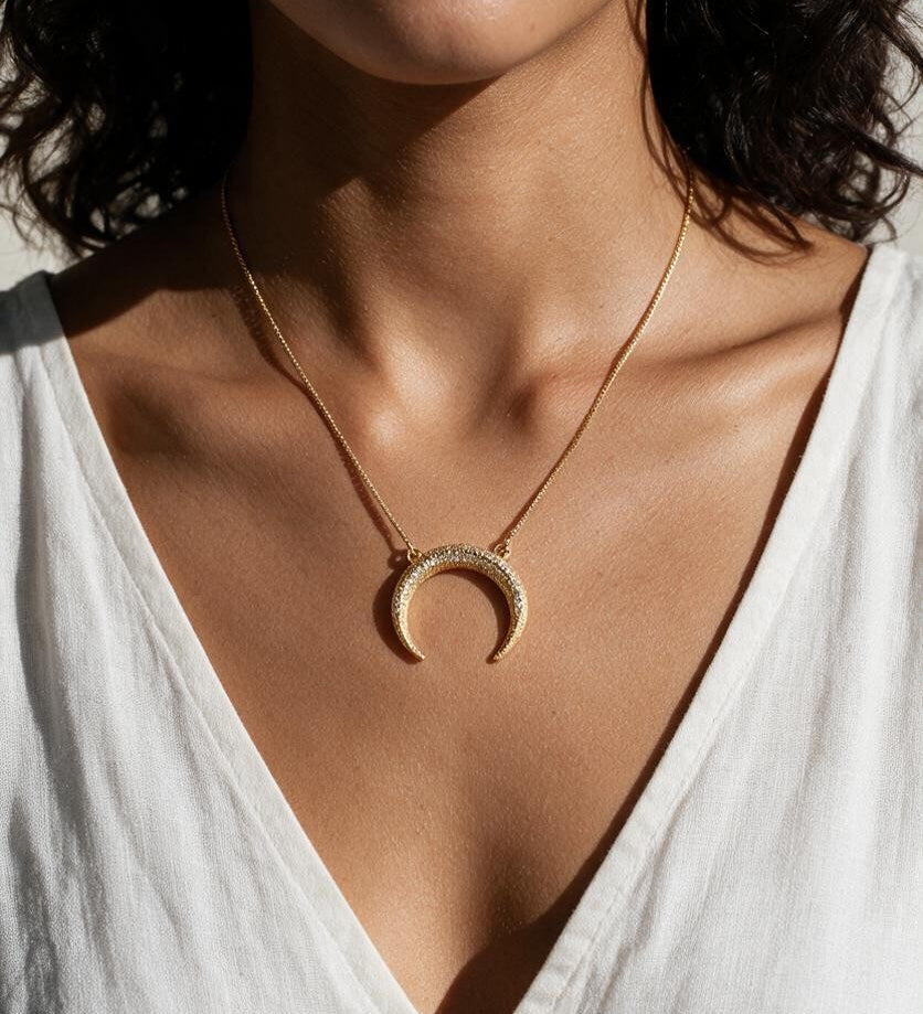 crescent moon necklace, pavé horn pendant, gold crescent necklace, celestial pendant necklace, moon horn necklace on model, dainty crescent jewelry, crystal crescent necklace
