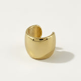 This bold gold ear cuff features a sculptural, domed silhouette that tapers from a wide, rounded front into a slim open back, creating a modern, architectural profile. The smooth, high-polish gold surface curves seamlessly to wrap around the ear, while the open-back design allows for a flexible, adjustable fit with no piercing required. Photographed at an angle against a clean white background, the cuff displays both its glossy exterior and brushed interior finish, along with a hallmark stamp near the openi