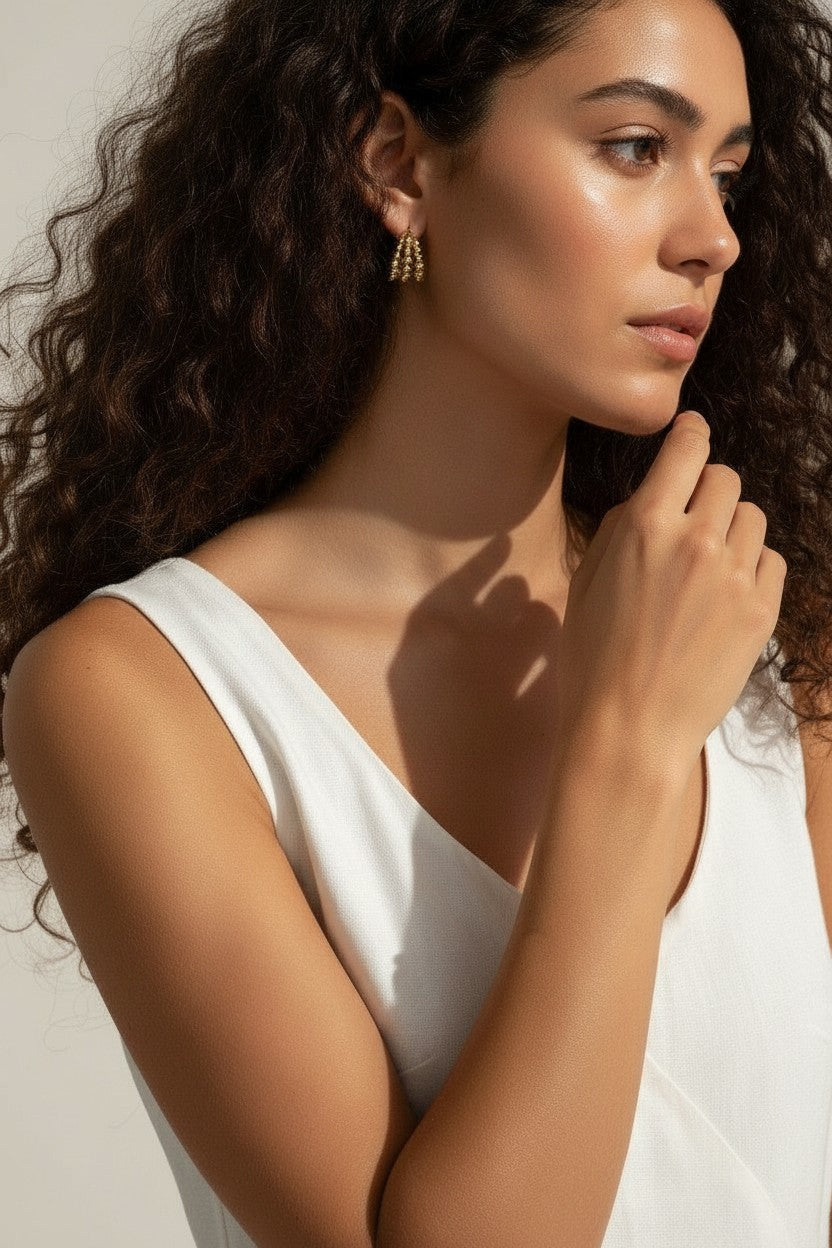 gold beaded hoop earrings on model, cluster hoop earrings worn, textured gold hoops styled, tiered gold earrings on ear, statement beaded earrings lifestyle, chunky gold hoops worn, sculptural gold earrings on model