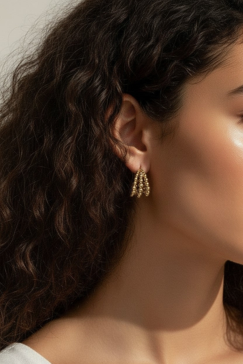 gold beaded hoop earrings on model, cluster hoop earrings worn, textured gold hoops styled, tiered gold earrings on ear, statement beaded earrings lifestyle, chunky gold hoops worn, sculptural gold earrings on model