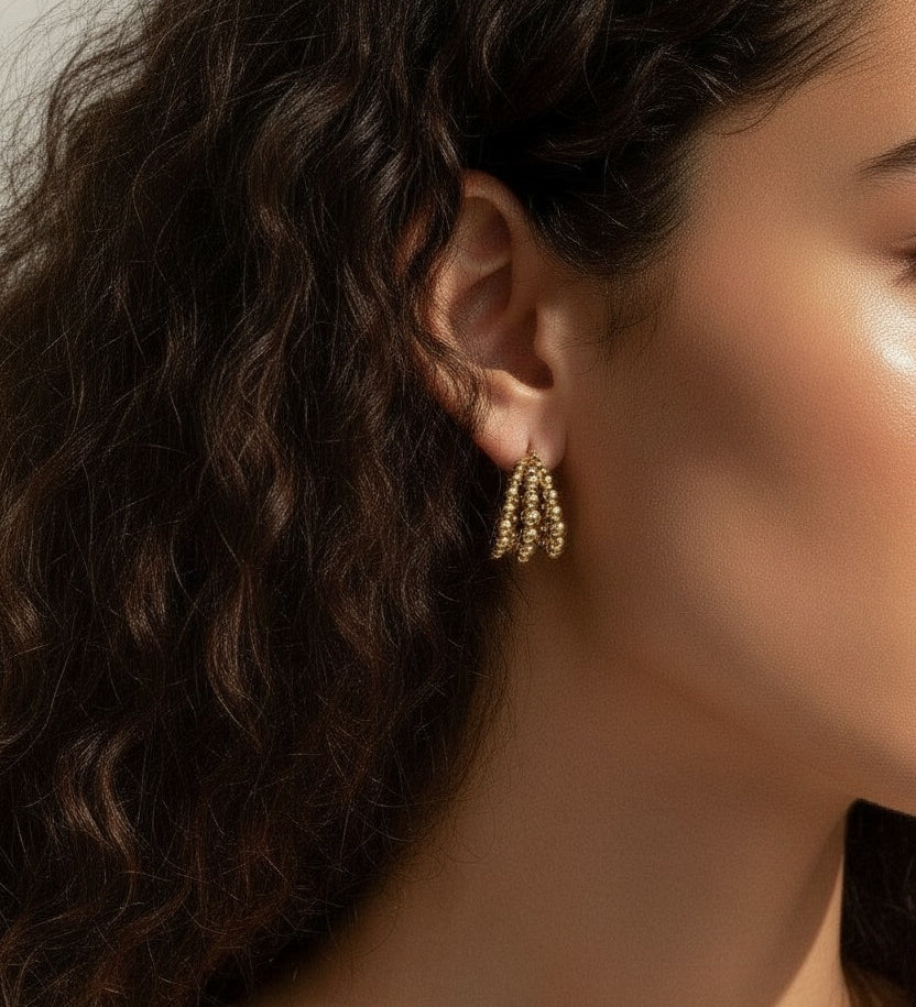 gold beaded hoop earrings on model, cluster hoop earrings worn, textured gold hoops styled, tiered gold earrings on ear, statement beaded earrings lifestyle, chunky gold hoops worn, sculptural gold earrings on model
