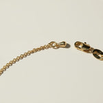 gold pearl bracelet clasp, lobster clasp detail jewelry, gold chain closure close-up, jewelry clasp macro shot, gold bracelet hardware detail, maker's mark jewelry tag