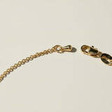 gold pearl bracelet clasp, lobster clasp detail jewelry, gold chain closure close-up, jewelry clasp macro shot, gold bracelet hardware detail, maker's mark jewelry tag