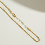 layered box chain necklace flat lay, cascading gold necklace clasp, multi strand necklace detail, box chain construction, 18k gold layered necklace, graduated chain necklace clasp, gold necklace extender chain, delicate box link chain