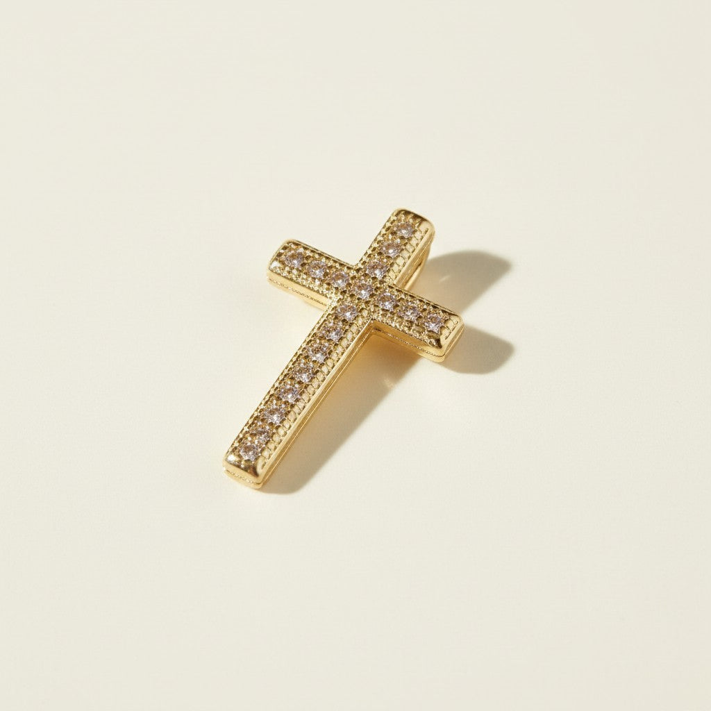 Gold Pavé Cross Pendant Charm, This gold cross pendant charm is fully encrusted in sparkling pavé crystals, with each facet lined in a milgrain-beaded edge for added texture and dimension. The classic cross silhouette offers a timeless, meaningful design suited for religious wear, confirmation and christening gifts, or as an everyday symbolic accent