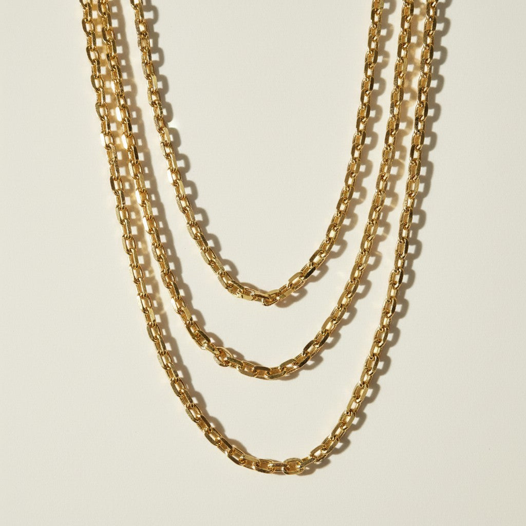 chunky gold chain necklace, oval link chain necklace, layered gold chains on model, gold cable chain necklace, statement chain necklace, graduated length chain layering, bold link necklace
