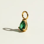 These interchangeable earring charms feature a pear-cut crystal set in a four-prong gold setting, topped with a round jump ring for easy attachment to hoops or huggies. Available in two colorways — a vivid emerald green and a sparkling clear crystal — the charms let shoppers customize and mix up their earring stack with a single pair of base hoops. 