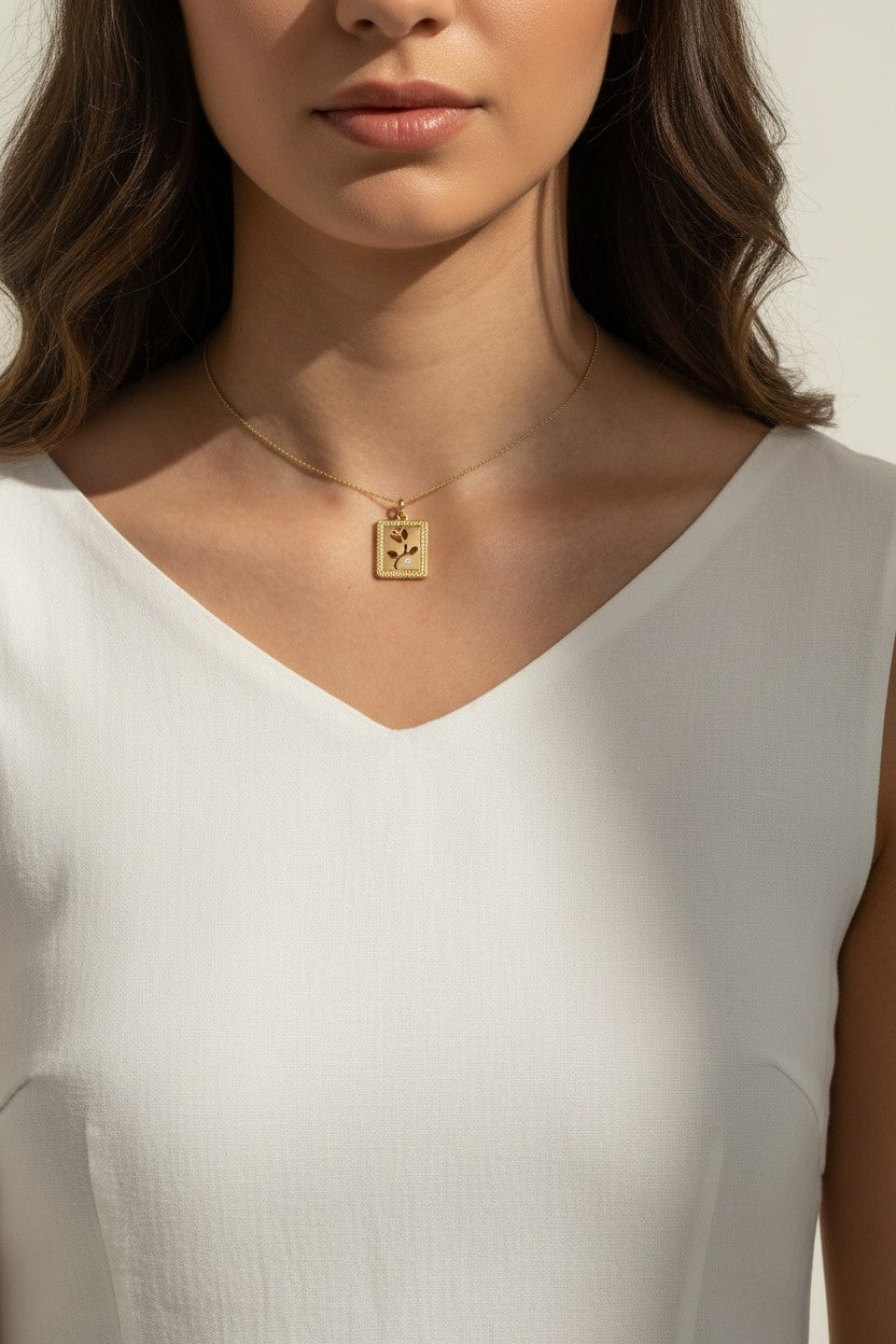 tulip pendant necklace on model, gold flower tag necklace lifestyle, botanical pendant necklace worn, engraved tulip necklace styled, dainty gold necklace on neck, CZ accent pendant, nature-inspired jewelry, rope-edge tag necklace