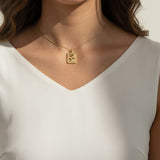 tulip pendant necklace on model, gold flower tag necklace lifestyle, botanical pendant necklace worn, engraved tulip necklace styled, dainty gold necklace on neck, CZ accent pendant, nature-inspired jewelry, rope-edge tag necklace