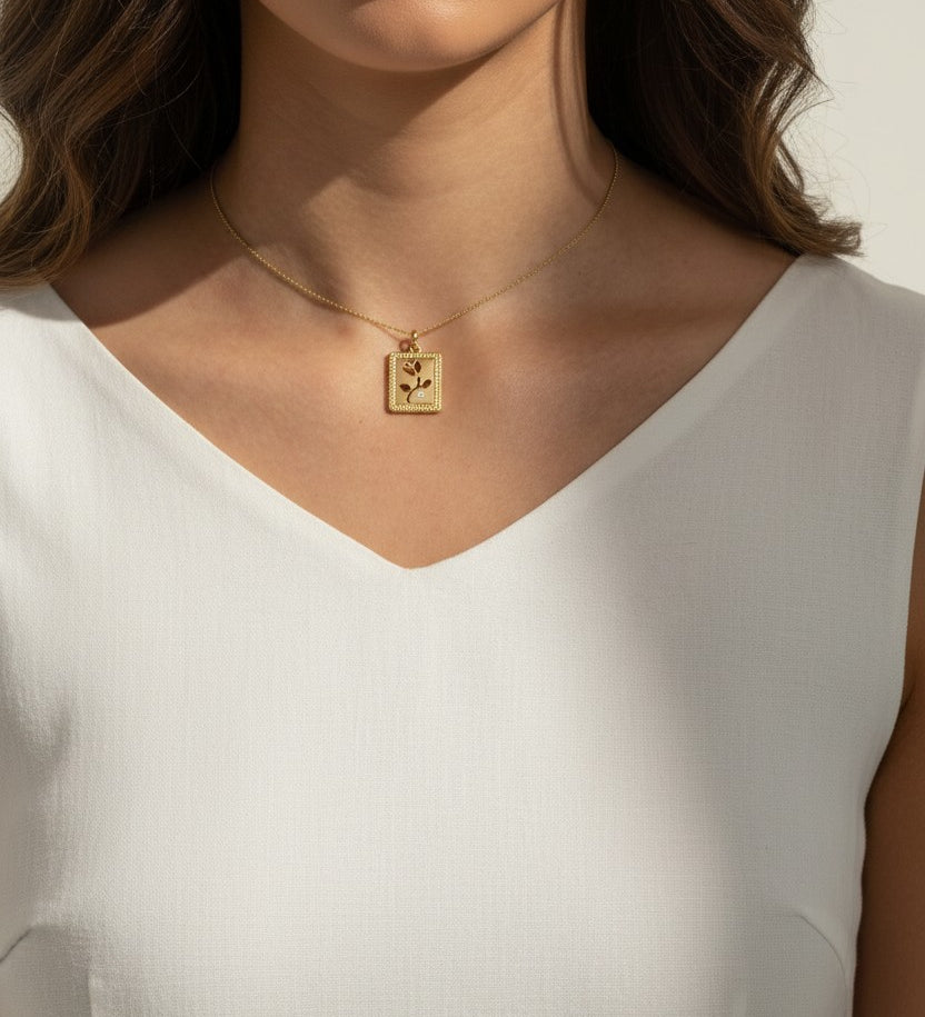 tulip pendant necklace on model, gold flower tag necklace lifestyle, botanical pendant necklace worn, engraved tulip necklace styled, dainty gold necklace on neck, CZ accent pendant, nature-inspired jewelry, rope-edge tag necklace
