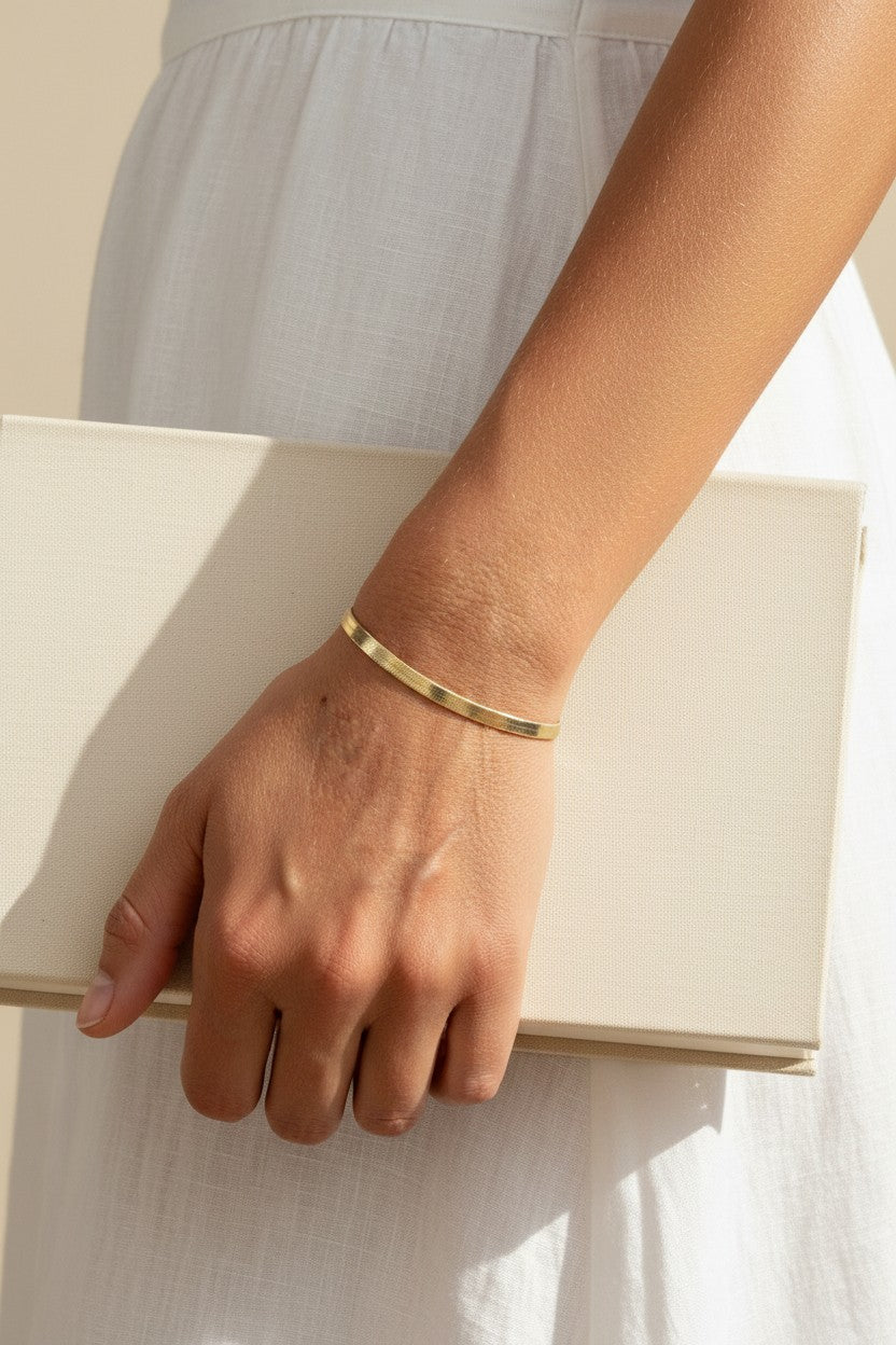 4mm herringbone bracelet on model, wide gold herringbone bracelet, flat link gold bracelet lifestyle, 18k gold overlay bracelet, chunky gold chain bracelet, everyday gold jewelry, herringbone chain wrist shot, minimalist gold bracelet