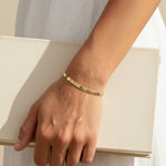 4mm herringbone bracelet on model, wide gold herringbone bracelet, flat link gold bracelet lifestyle, 18k gold overlay bracelet, chunky gold chain bracelet, everyday gold jewelry, herringbone chain wrist shot, minimalist gold bracelet