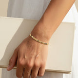 4mm herringbone bracelet on model, wide gold herringbone bracelet, flat link gold bracelet lifestyle, 18k gold overlay bracelet, chunky gold chain bracelet, everyday gold jewelry, herringbone chain wrist shot, minimalist gold bracelet