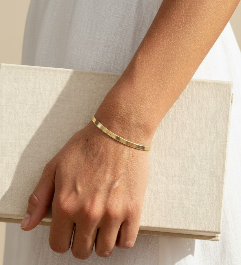 4mm herringbone bracelet on model, wide gold herringbone bracelet, flat link gold bracelet lifestyle, 18k gold overlay bracelet, chunky gold chain bracelet, everyday gold jewelry, herringbone chain wrist shot, minimalist gold bracelet