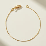 box chain bracelet flat lay, gold box link bracelet, delicate gold bracelet clasp, minimalist gold bracelet, 18k gold box chain, thin gold bracelet detail, dainty gold bracelet, gold bracelet clasp detail