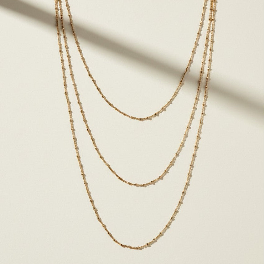 satellite chain necklace detail, beaded chain necklace close up, layered gold necklace texture, delicate gold chain detail, 18k gold satellite chain, dainty beaded necklace, graduated chain flat lay, faceted bead chain necklace