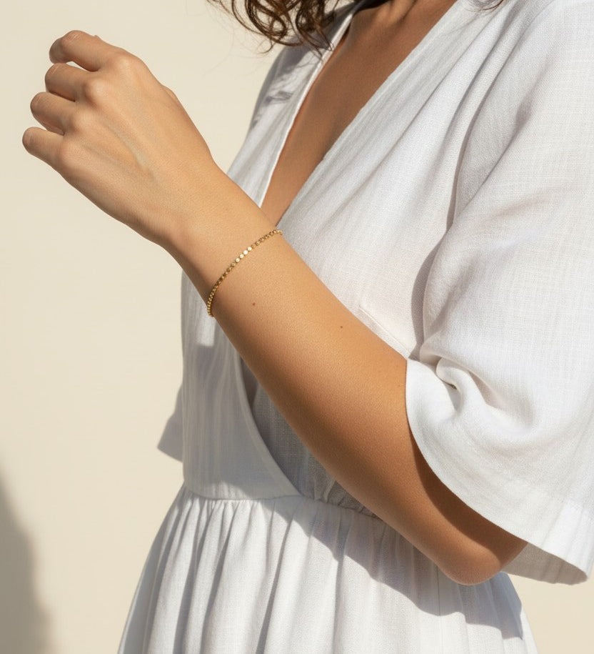 gold disc bracelet on wrist, dainty gold chain bracelet worn, minimalist bracelet lifestyle photo, gold beaded bracelet fit, everyday gold bracelet styled, sunlit jewelry photo