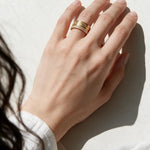 Greek key ring on model, wide gold band ring on hand, meander pattern ring, pavé band ring lifestyle, engraved gold statement ring, geometric gold band styled