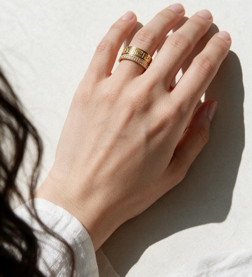 Greek key ring on model, wide gold band ring on hand, meander pattern ring, pavé band ring lifestyle, engraved gold statement ring, geometric gold band styled