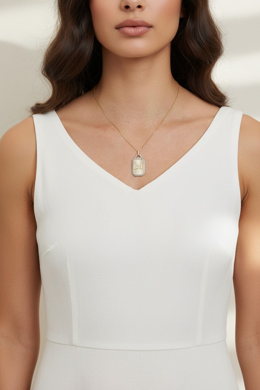 love pendant necklace on model, gold tag necklace lifestyle, sunburst pendant necklace worn, pavé love necklace styled, engraved love pendant on neck, long chain pendant necklace, statement gold necklace, script love necklace outfit