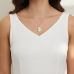 love pendant necklace on model, gold tag necklace lifestyle, sunburst pendant necklace worn, pavé love necklace styled, engraved love pendant on neck, long chain pendant necklace, statement gold necklace, script love necklace outfit