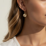 sunburst disc earrings, gold drop earrings on model, heart pavé earrings, huggie hoop drop earrings, textured gold earrings, statement drop earrings, sparkle disc earrings, everyday gold earrings