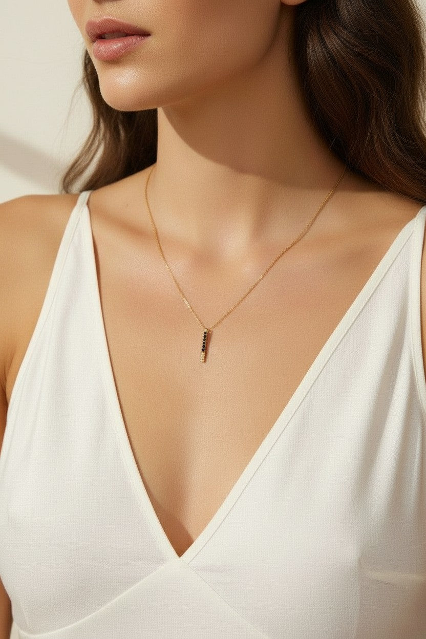 black pave dagger necklace worn, gold necklace with black crystals styled, minimalist pendant necklace fit, edgy gold necklace lifestyle photo, dainty necklace close-up, black crystal pendant on model