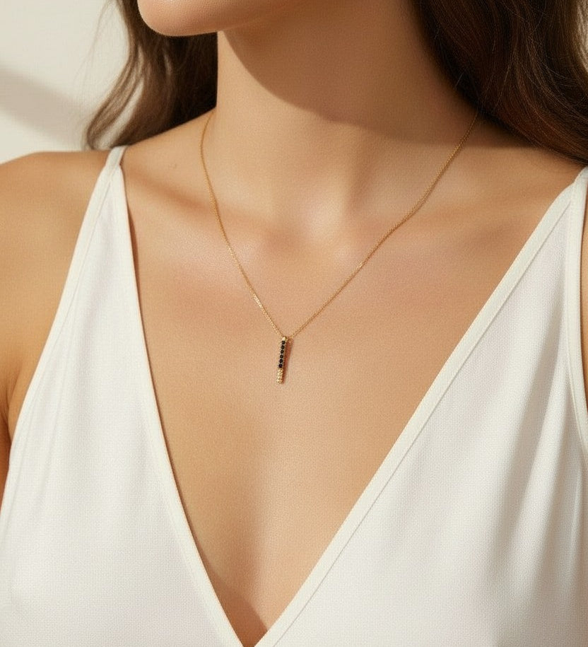 black pave dagger necklace worn, gold necklace with black crystals styled, minimalist pendant necklace fit, edgy gold necklace lifestyle photo, dainty necklace close-up, black crystal pendant on model